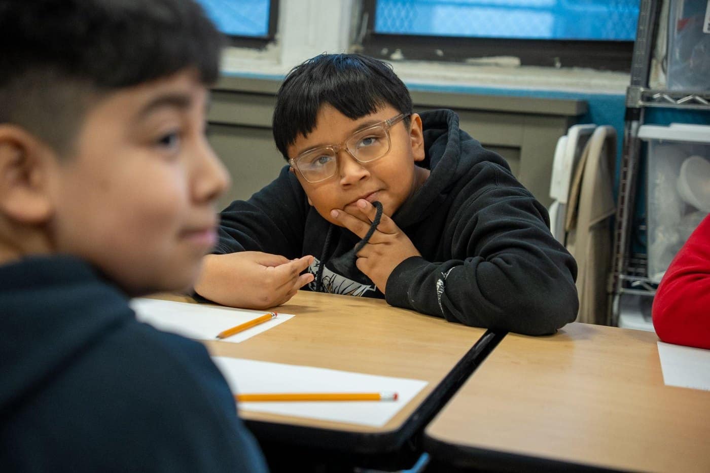 A student pauses thoughtfully during a classroom reflection activity.